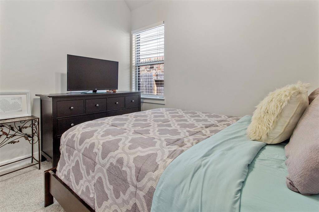Secondary bedroom features awindow and plush carpet.