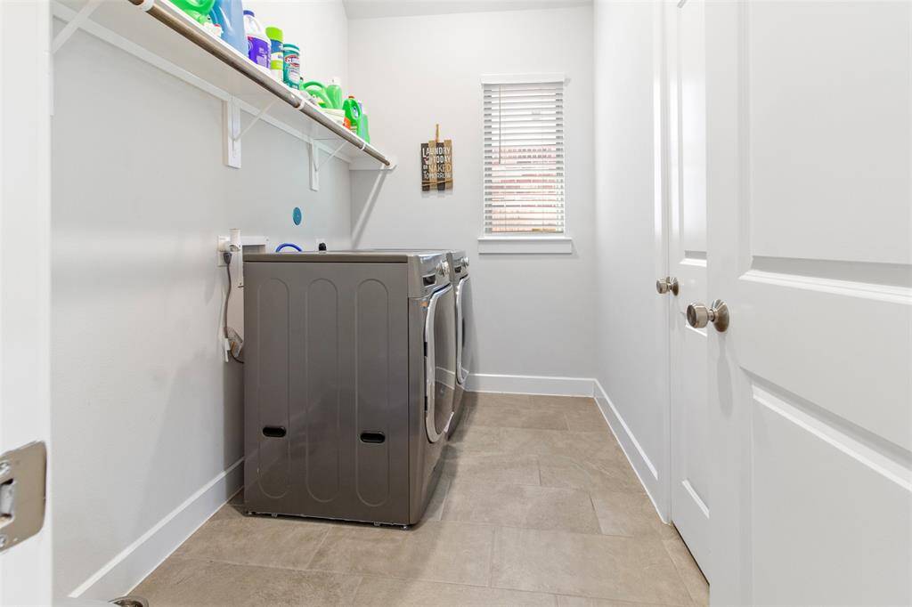 The laundry room features tile floors,washer and dryer connections, window, andplenty of storage space.