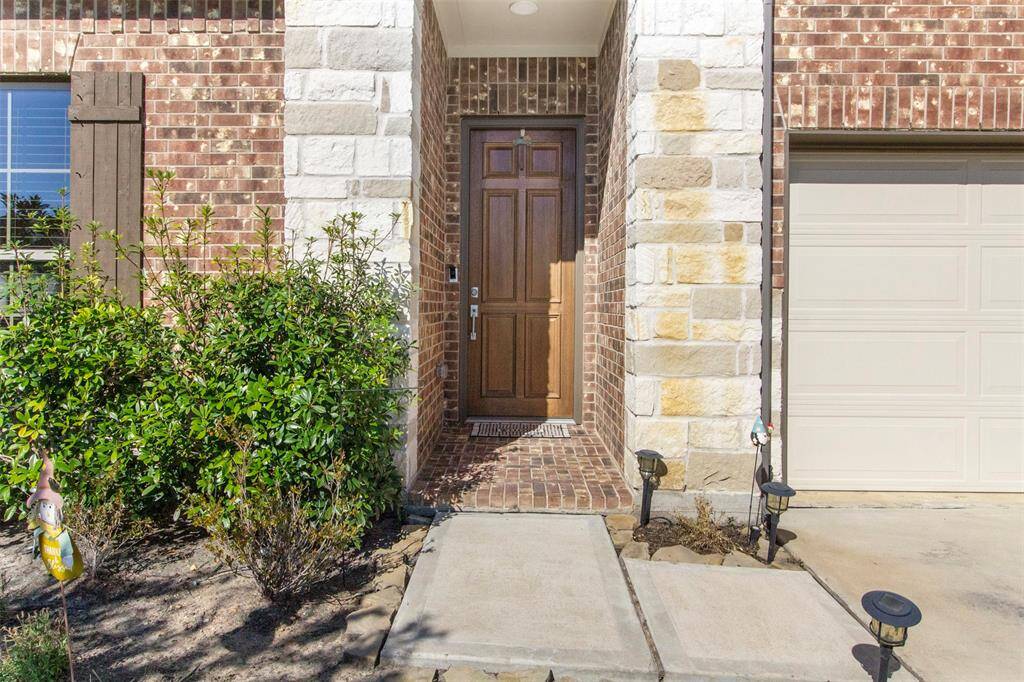 Approaching the front door you will see the beautiful brick and stone elevation, covered front porch, and lovely landscaping.