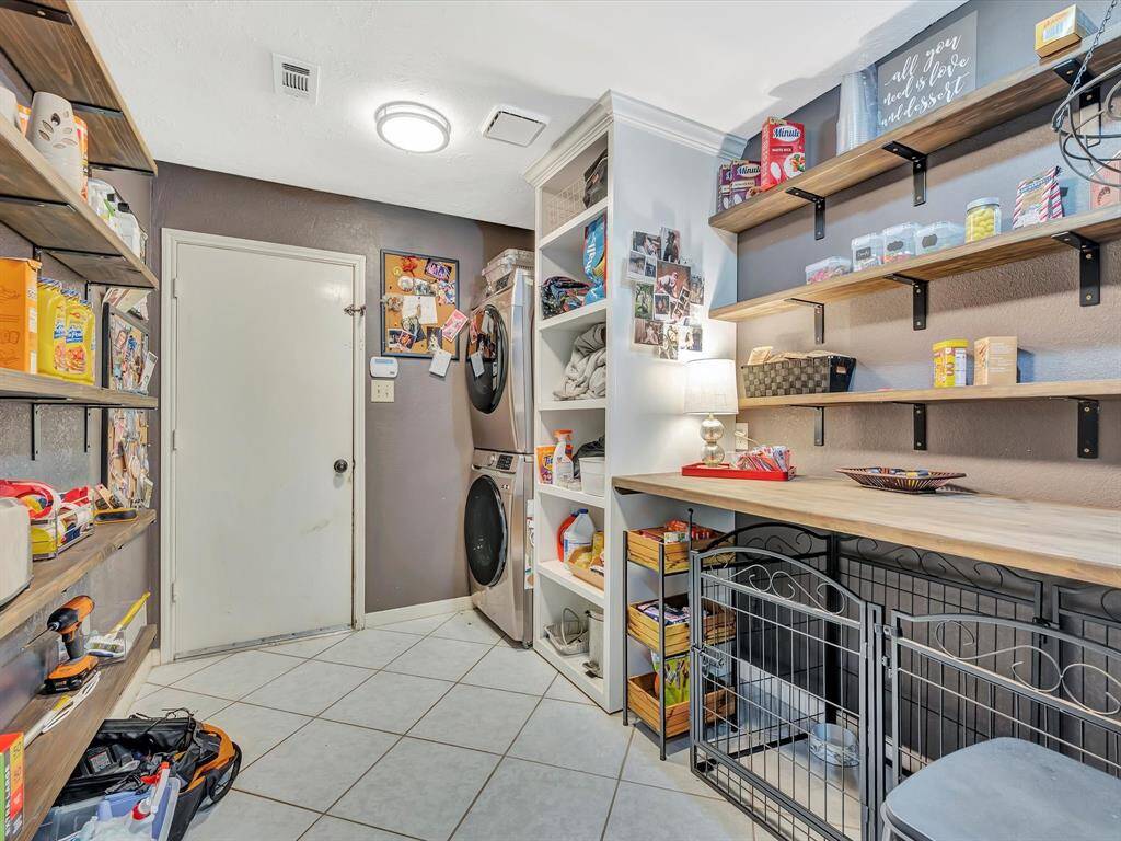 The utility room features open shelving for easy access to essentials,could be used as a butler's pantry with additional storage and workspace for organizing pantry items. Together, they provide a functional and efficient layout