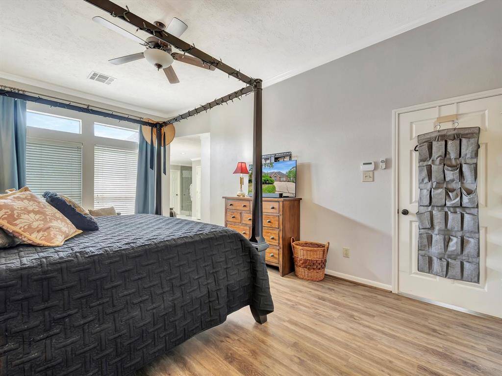 The bedroom is filled with natural light, thanks to large windows that brighten the space. The room offers easy access to the en suite bathroom, creating a seamless flow between the two areas.