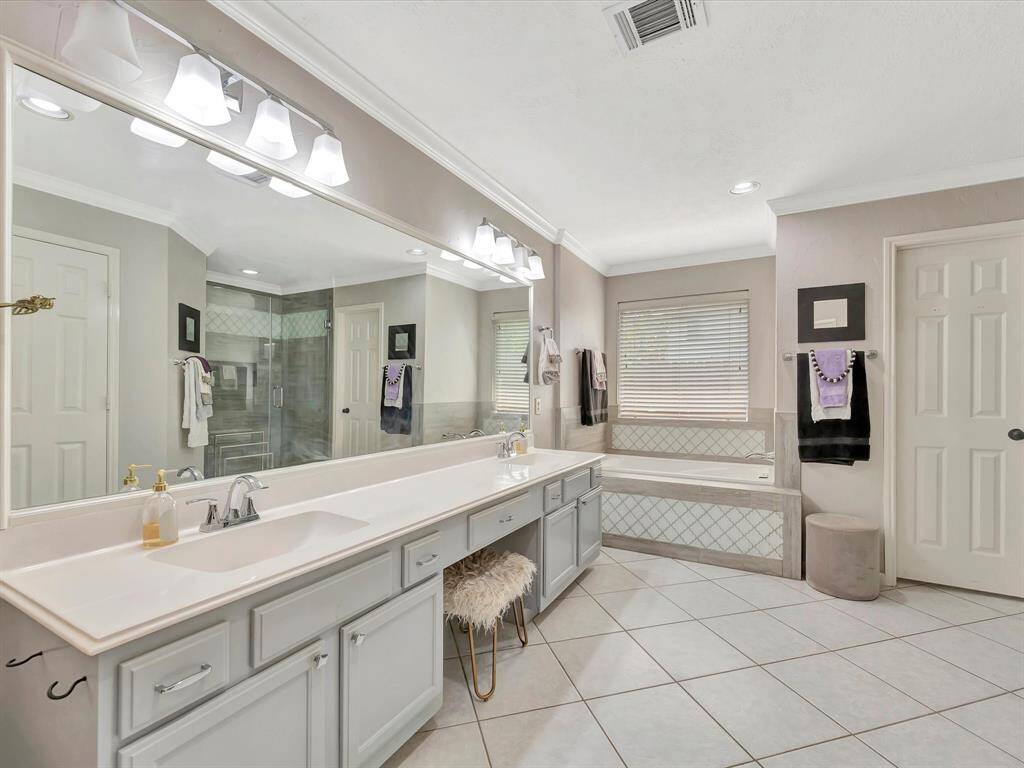 The bathroom boasts a long, sleek countertop that stretches across the space, offering ample room for daily essentials.