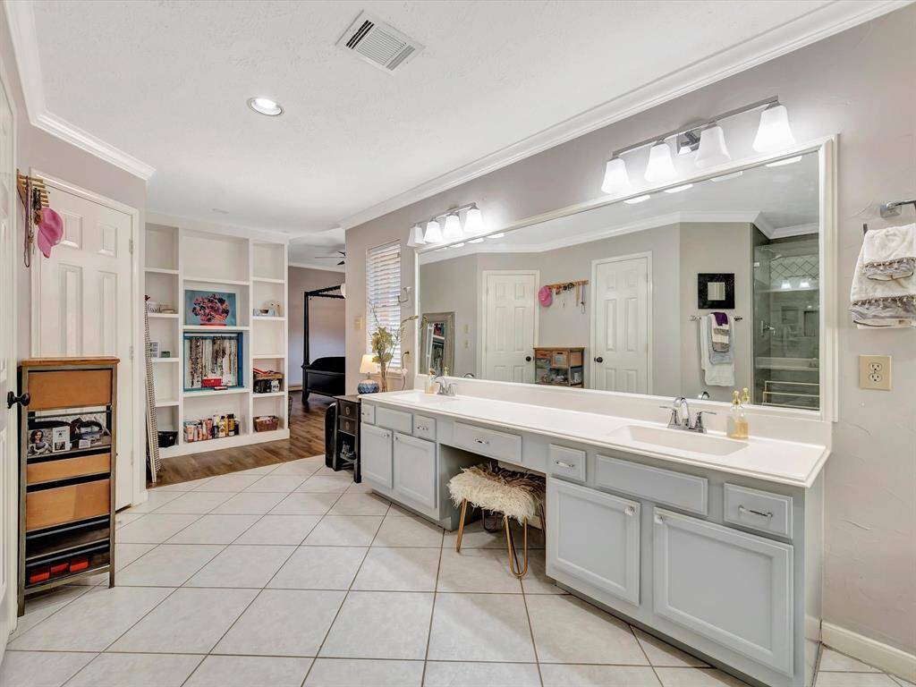 The primary bathroom offers both style and function with built-in shelving that keeps everything neatly organized. With plenty of space for toiletries, towels, and décor, getting ready each day is a breeze. The thoughtful layout ensures your essentials are always within reach, making your morning routine seamless and stress-free