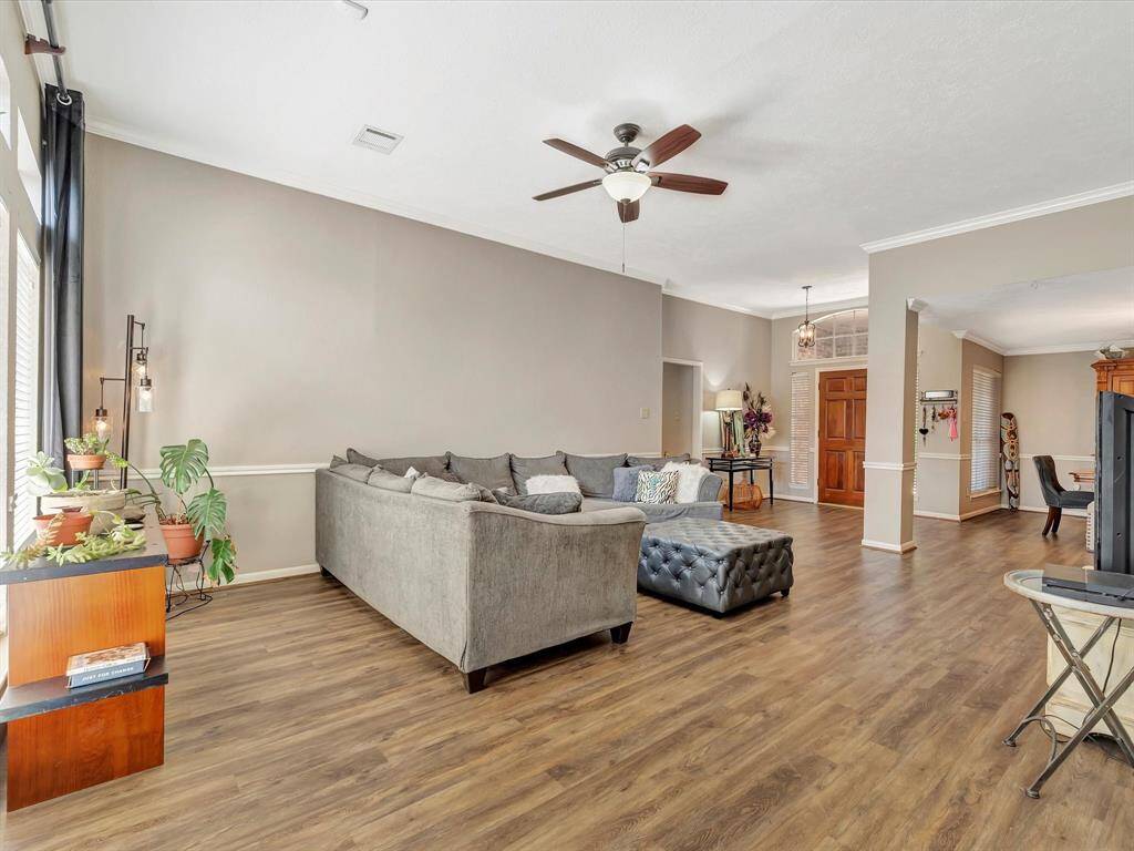 This view from the den captures the expansive living room and the open formal dining room, offering a harmonious flow between spaces that’s perfect for both casual living and hosting special occasions