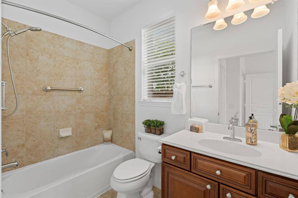 The en-suite offers the flexibility of a relaxing tub or a refreshing shower with a handheld showerhead, providing a welcoming space where guests can unwind and feel at home.