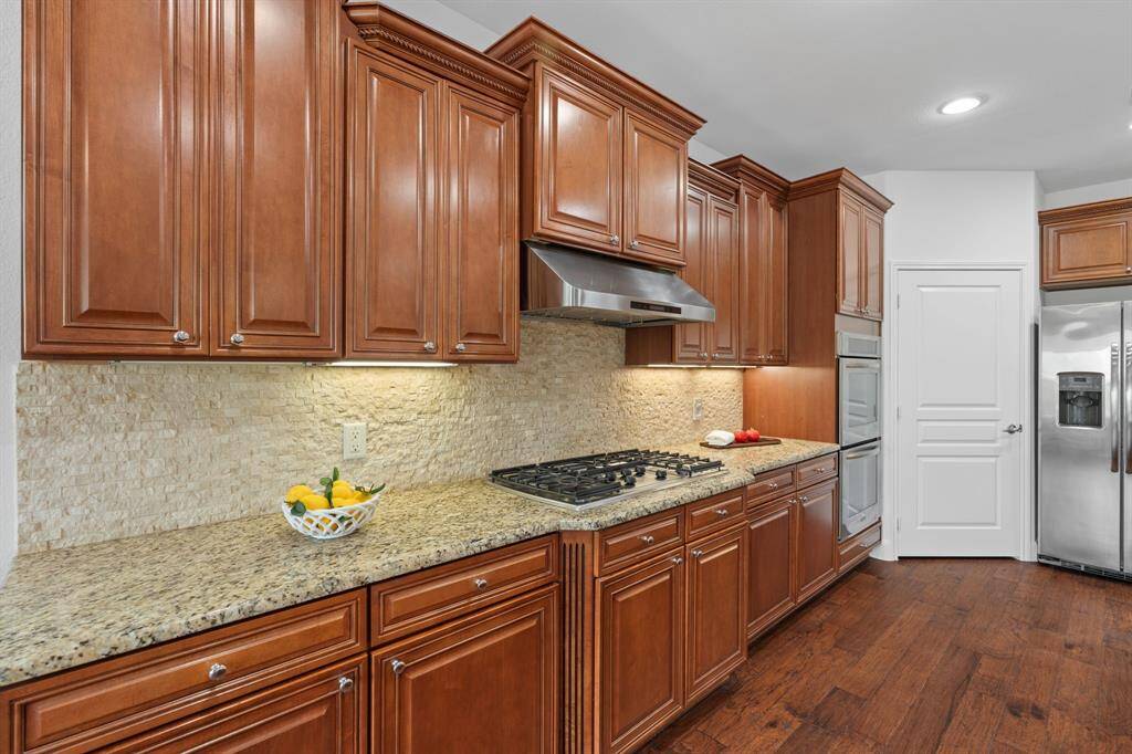 The kitchen boasts 42" Shaker-style cabinets with an intricate rope design adorning the tops—Level 5 craftsmanship paired with upgraded granite countertops for a truly sophisticated finish. Refrigerator included.
