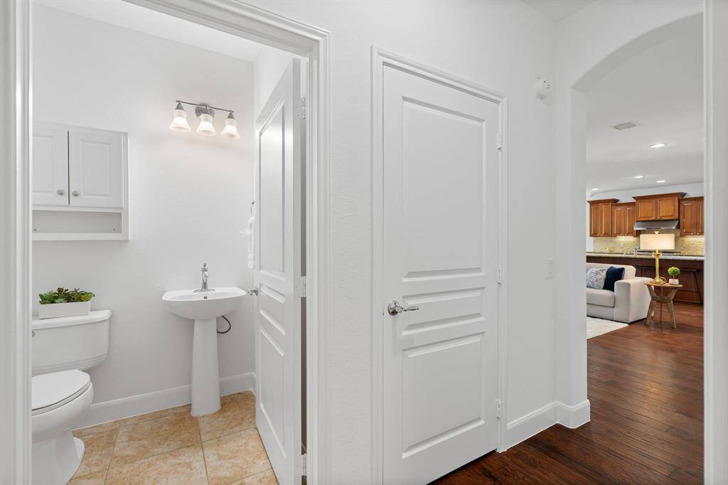 A charming half bath for guests, featuring a classic pedestal sink, adding both style and convenience.