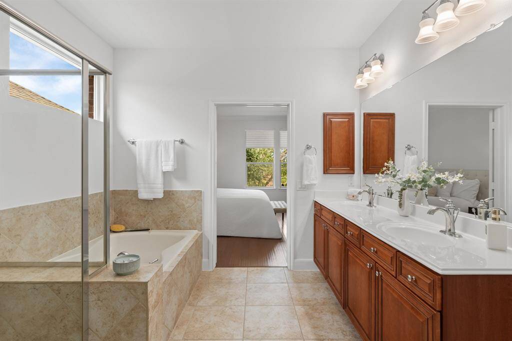 After a day of pickleball, unwind in the soothing tub or enjoy a refreshing shower. The bath also features a medicine cabinet and dual sinks for added convenience.