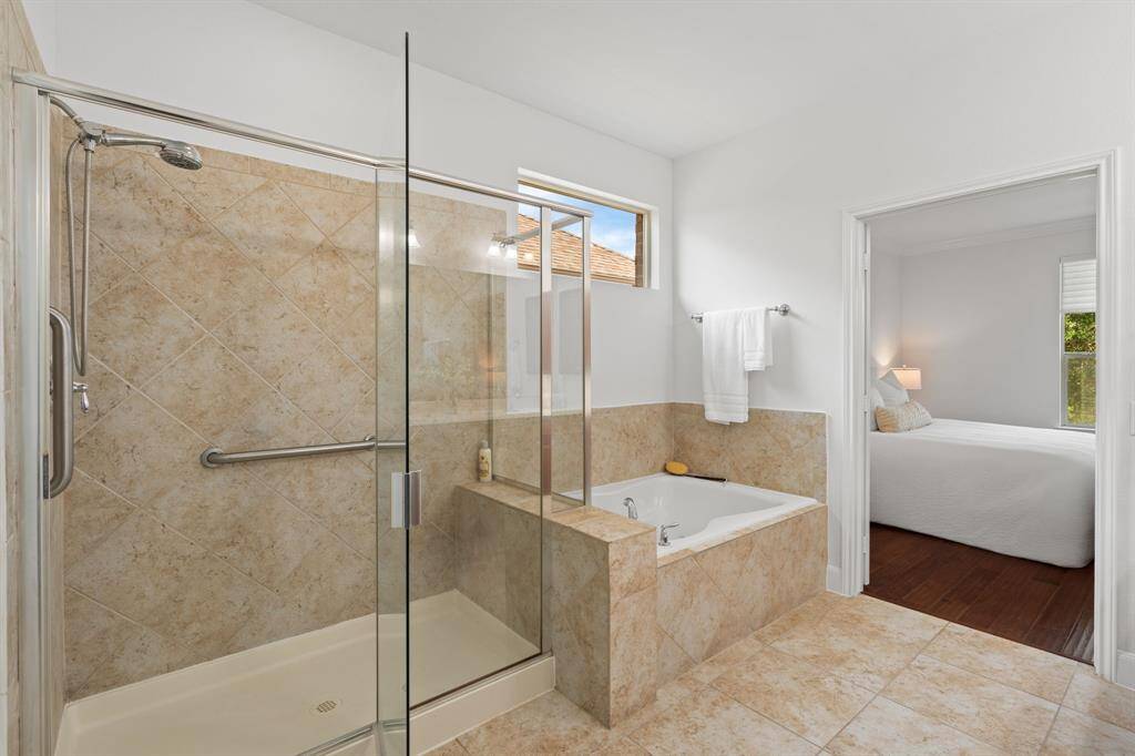 The owner’s bath shower is equipped with a convenient grab bar for added safety, along with a handheld showerhead for a more versatile and comfortable experience.