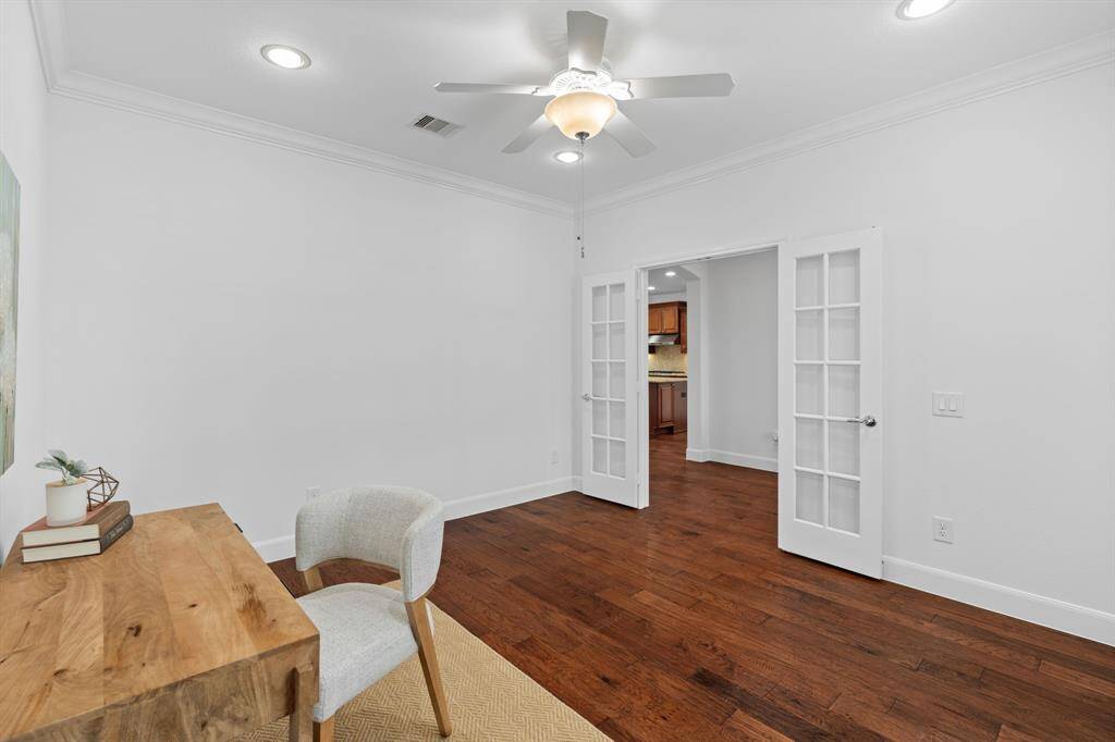 Glistening French doors, classic plantation shutters, and a ceiling fan add both charm and function to this thoughtfully designed space.