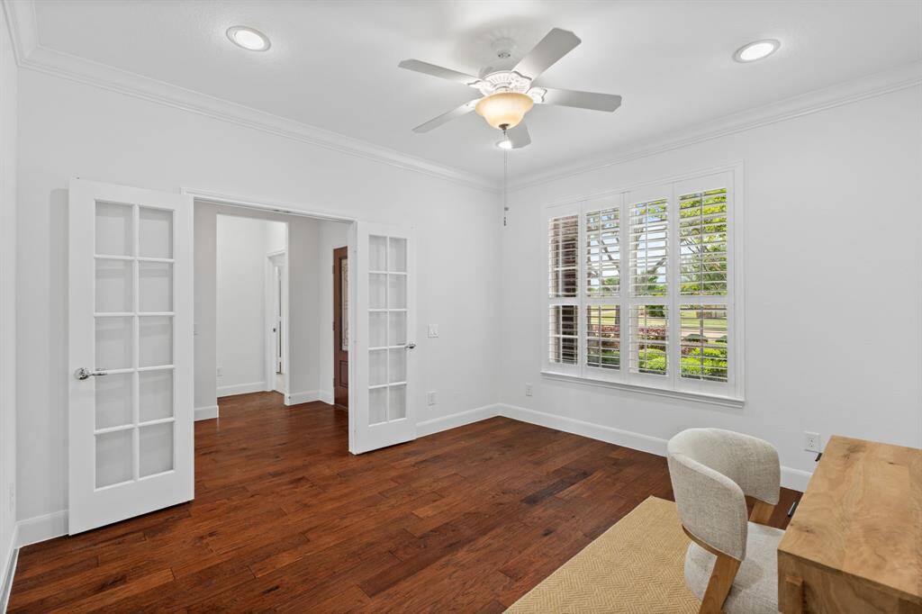 Elegant 5¼" baseboards and crown molding pair beautifully with stunning plantation shutters, offering a peaceful view of the serene front yard.