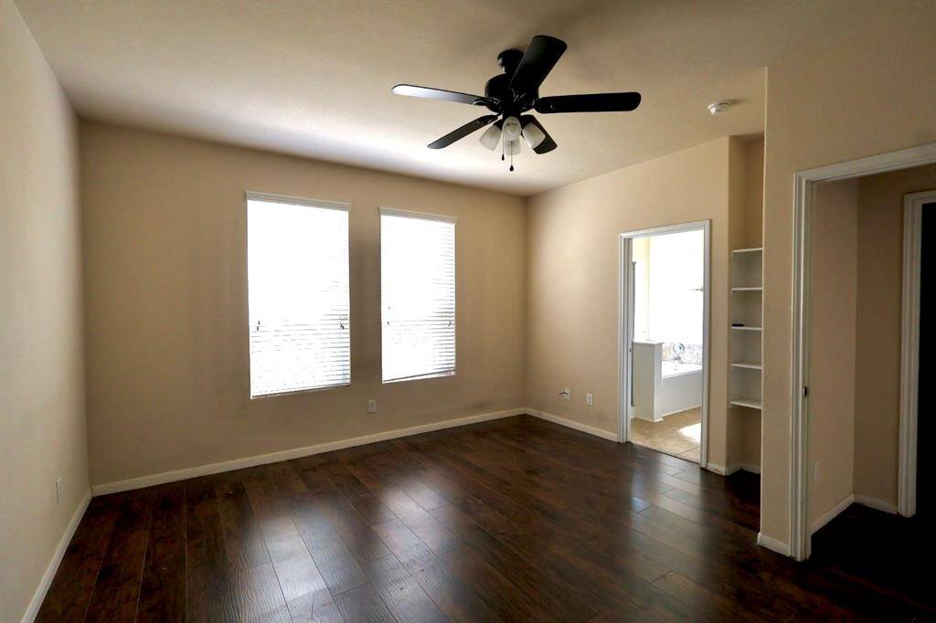 Primary bedroom with wood floors and ensuite bathroom located on first floor