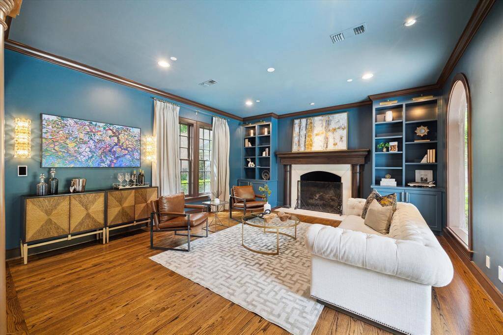 A striking blend of comfort and elegance — note the designer lighting, curated shelves, and millwork framing every detail.