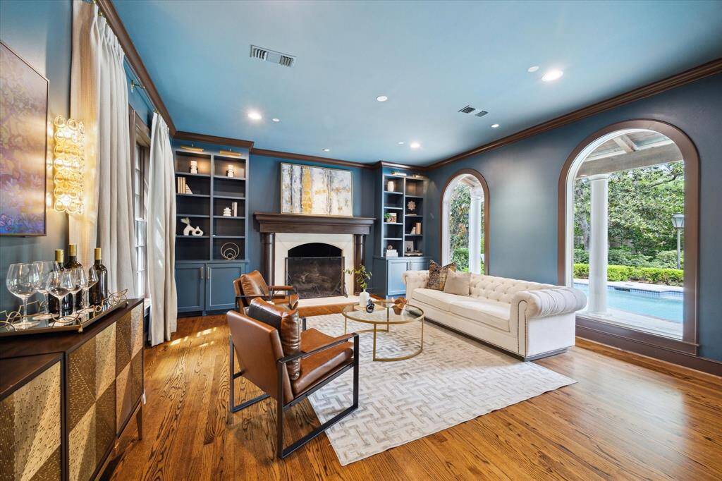 Floor-to-ceiling arched windows frame serene backyard views and allow natural light to spill across this stunning entertaining space.