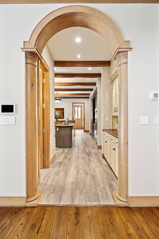 Grand arched hallway transitions from formal to casual living, setting a tone of architectural elegance throughout the home.