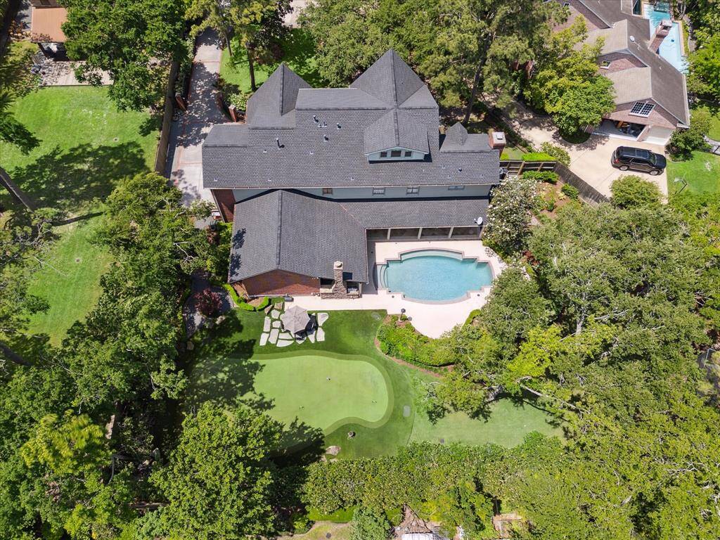 Expansive grounds showcase the full scale of the property, with private motor court, outdoor living pavilion, and 6-hole Celebrity Greens putting course surrounded by trees and high landscaping for super back yard privacy.