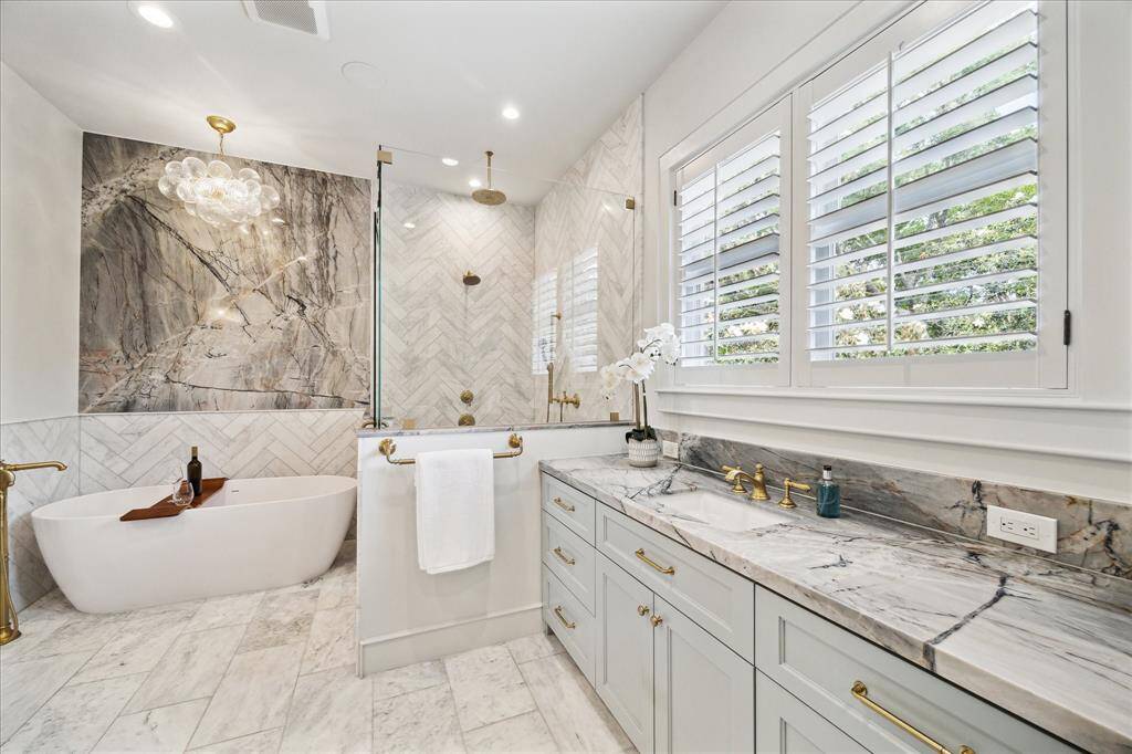 Dual vanities with elegant cabinetry, expansive storage, and picture-frame windows that flood the space with natural light.