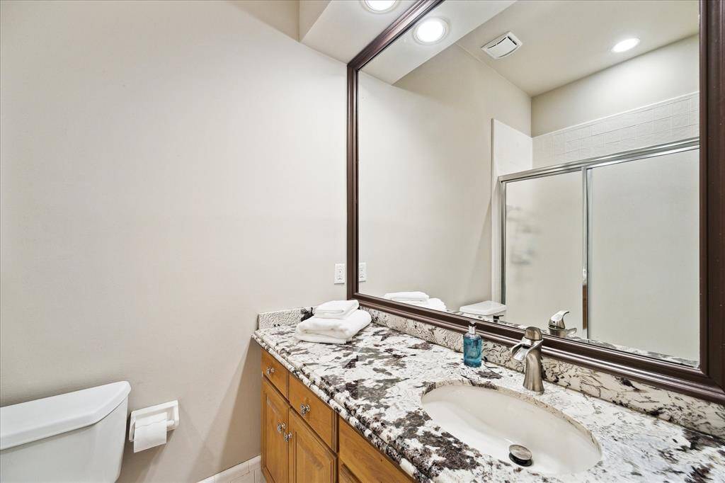 Secondary bathroom with granite counters, updated fixtures, and oversized mirror—perfect for guests or everyday use.