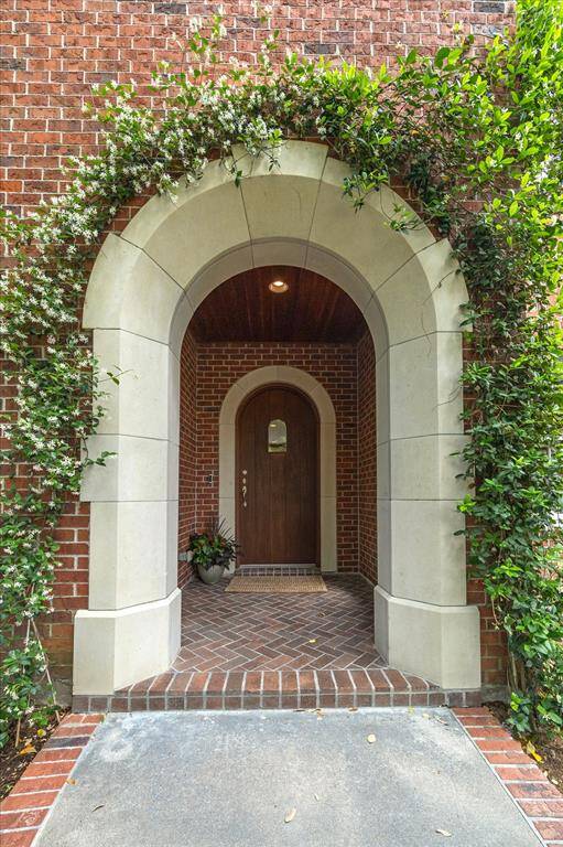 A dramatic arched entry wrapped in jasmine sets a refined and romantic tone for this exceptional estate.