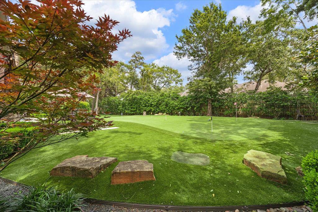 A dream for golf lovers—professionally installed six-hole putting green by Celebrity Greens surrounded by mature landscaping and stone features.