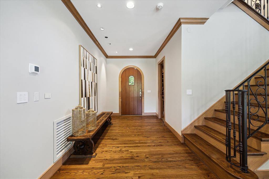 Grand yet welcoming, the formal entry features custom millwork, oak floors, and arched accents that echo the home’s architectural pedigree