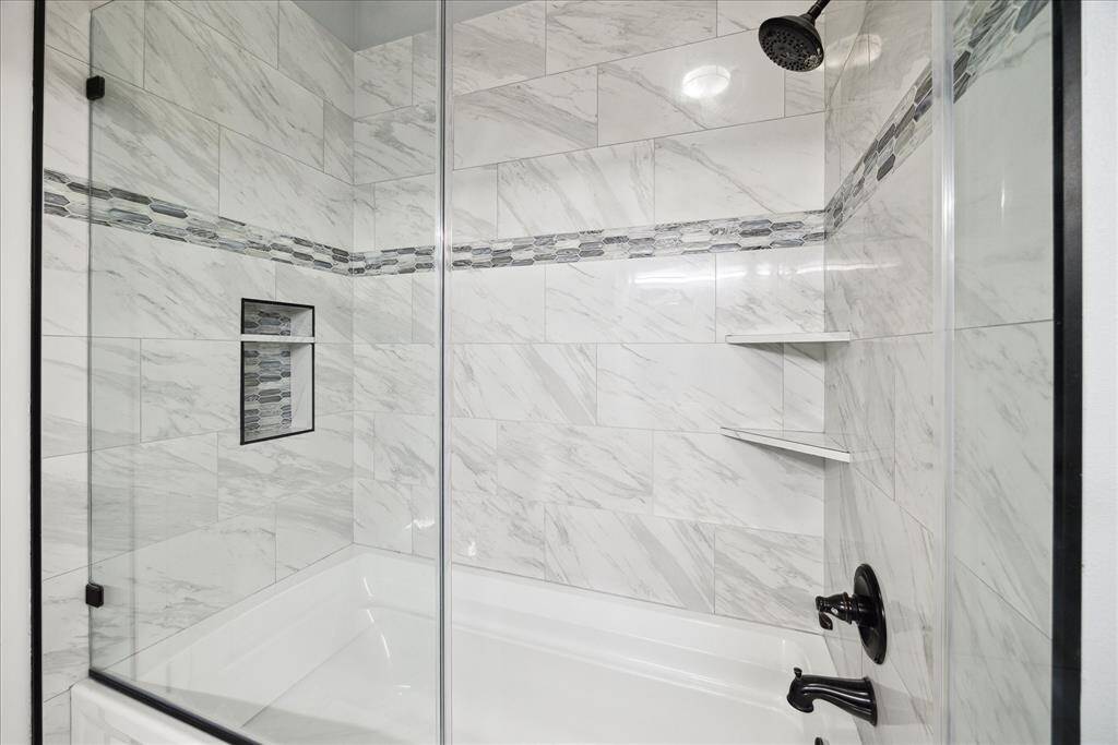 Primary tub/shower with frameless glass wall.