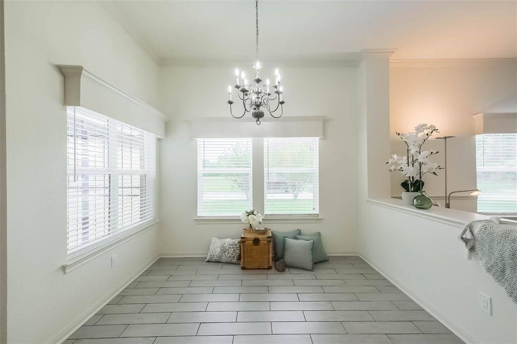 Coming out of the office past the front living room is the dining area with chandelier and lots of natural light.