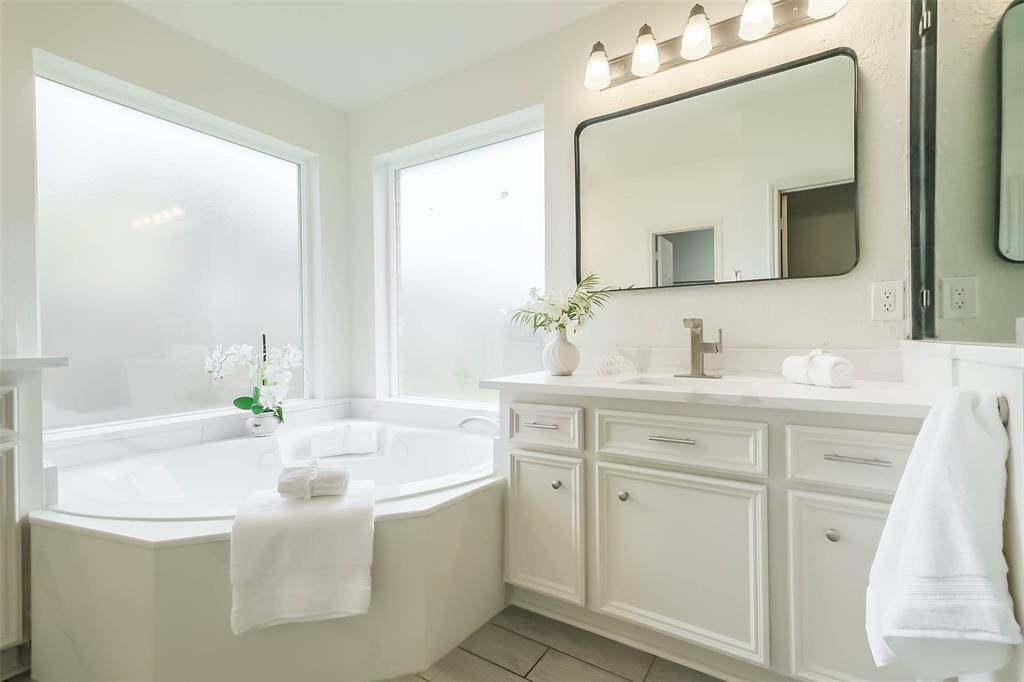 Two vanities with new quartz countertops, undermount sink and temperature sensing stainless steel faucets with pull outs.