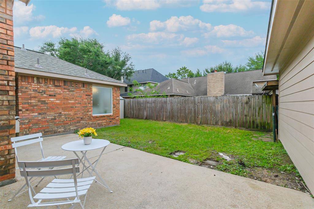 The back patio has access from the primary suite (door to the right) as well as from the back door and garage.