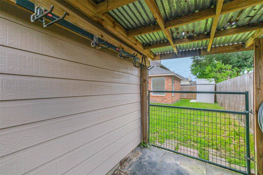 Nice sized storage shed behind the house. View of the covered storage area behind the garage, great for lawn equipment.