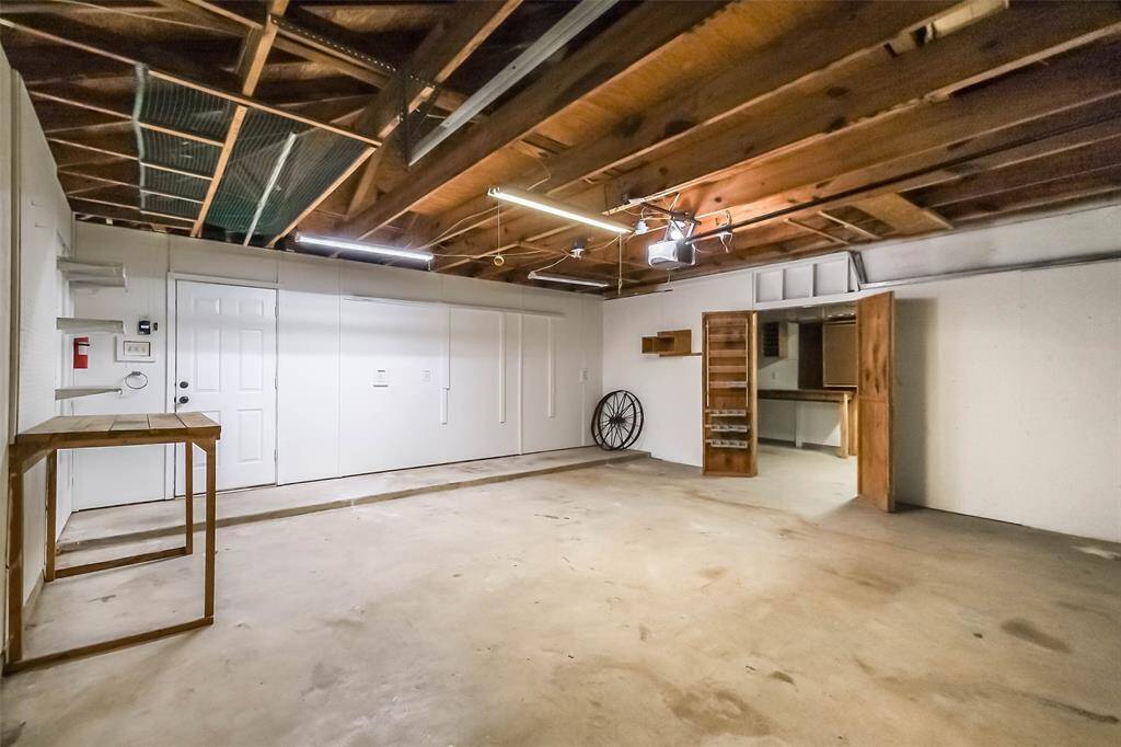 Large wood gate to the right of the garage leads into the back yard. Three car detached garage with last bay converted into a workshop.