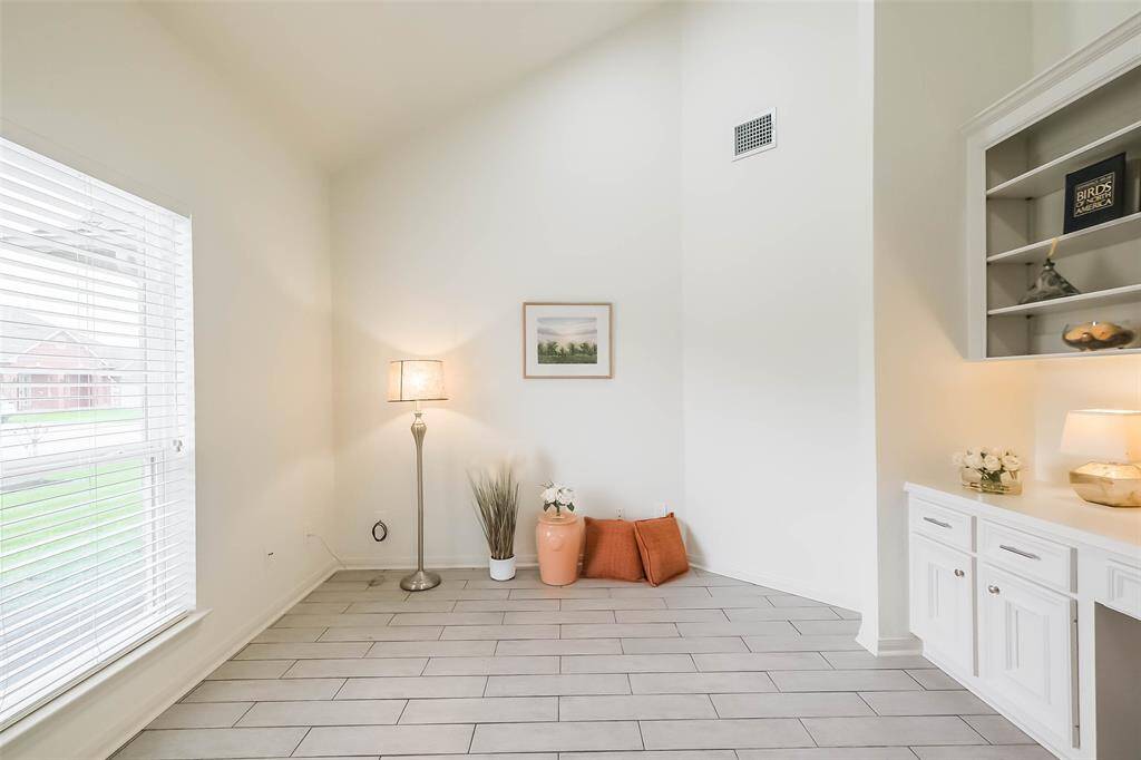 From the living room, you can see the office, dining room, kitchen and family room beyond. Arched doorway leads to the front secondary bedrooms and full bath in this split bedroom plan home.