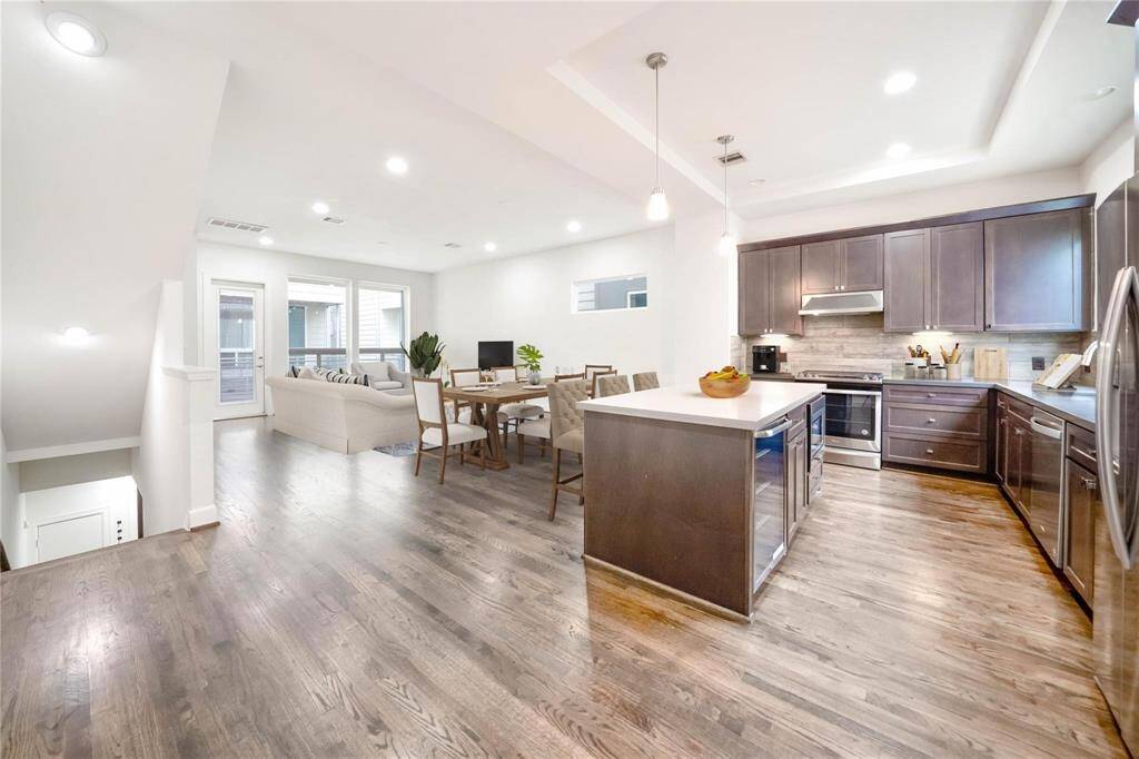 The stunning living area on the second floor features an open-concept kitchen that flows seamlessly into the spacious living room. Expansive windows bring in plenty of natural light, keeping the space bright and inviting. Throughout the home, you'll find sleek, contemporary finishes that add a modern touch to every room.
