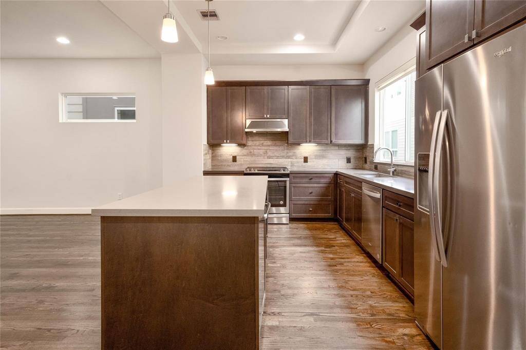 The modern kitchen features a sleek island with ample prep space, a gas cooktop for precise cooking, and plenty of cabinet space for all your storage needs. With its open design, the kitchen flows effortlessly into the living room, creating a perfect space for entertaining and daily living.
