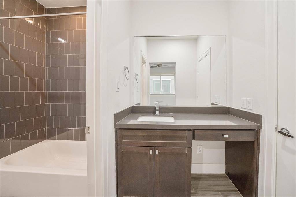 The beautiful en suite bathroom features a luxurious full-entry shower, offering a spa-like experience. The vanity is complemented by a sleek sink and convenient under-cabinet storage, providing both style and functionality to keep your essentials organized.