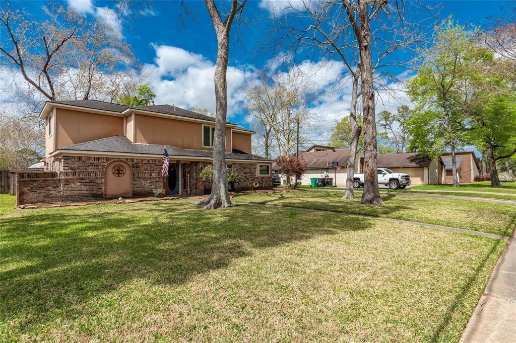 This expansive front yard is shaded by towering trees, offering both beauty and tranquility.