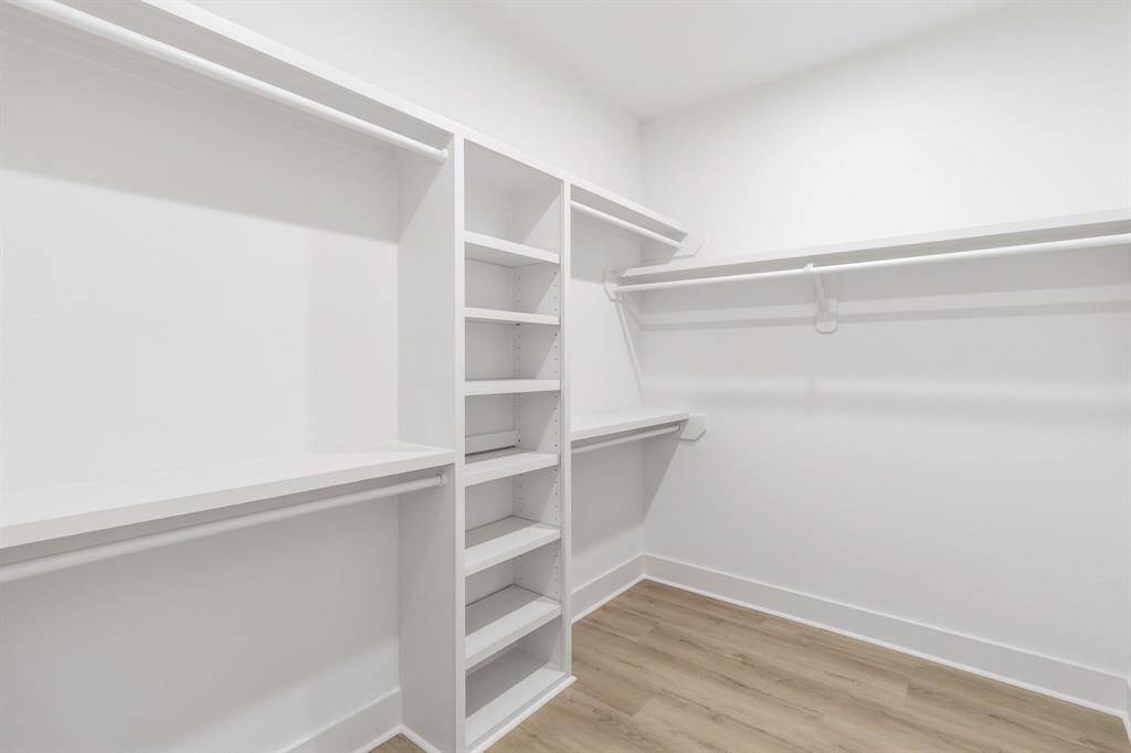 The spacious primary closet with built-in shelves.