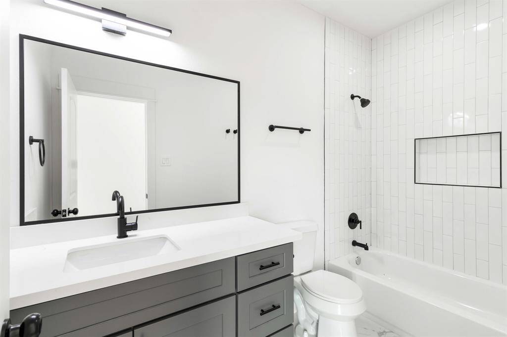 The guest bathroom offers a tub and spacious vanity.