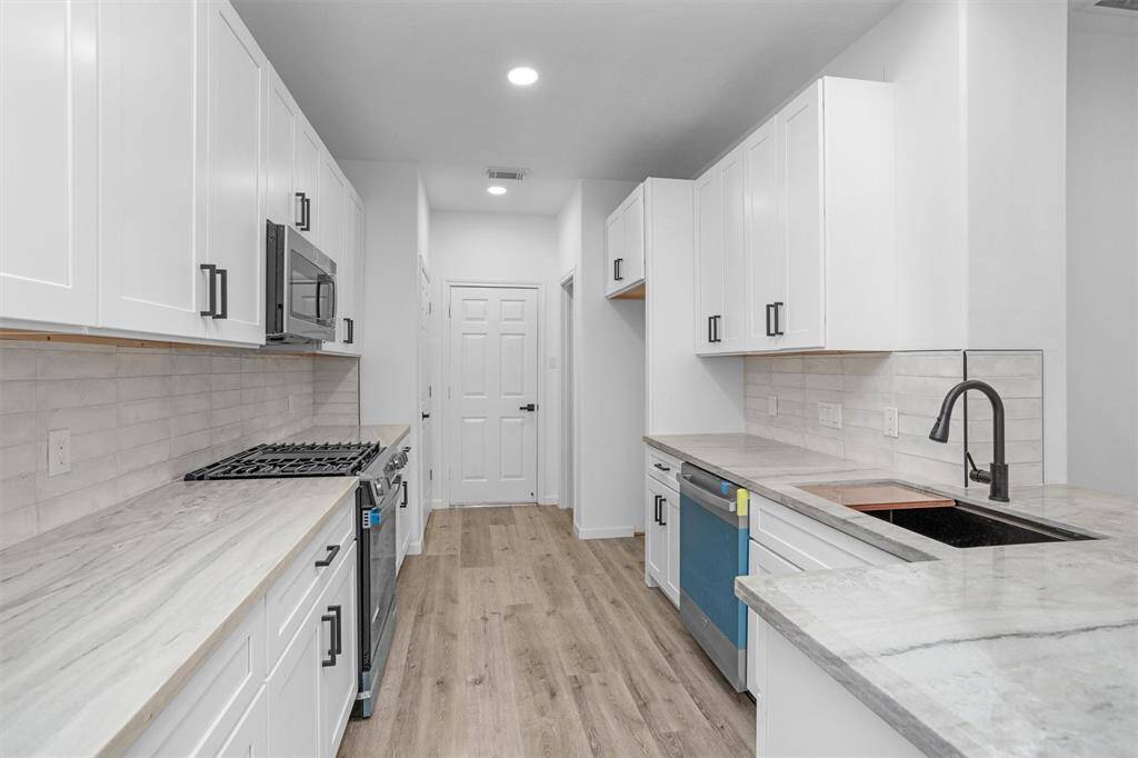 Across the kitchen is the entrance to the garage, also a large pantry and separate broom closet.