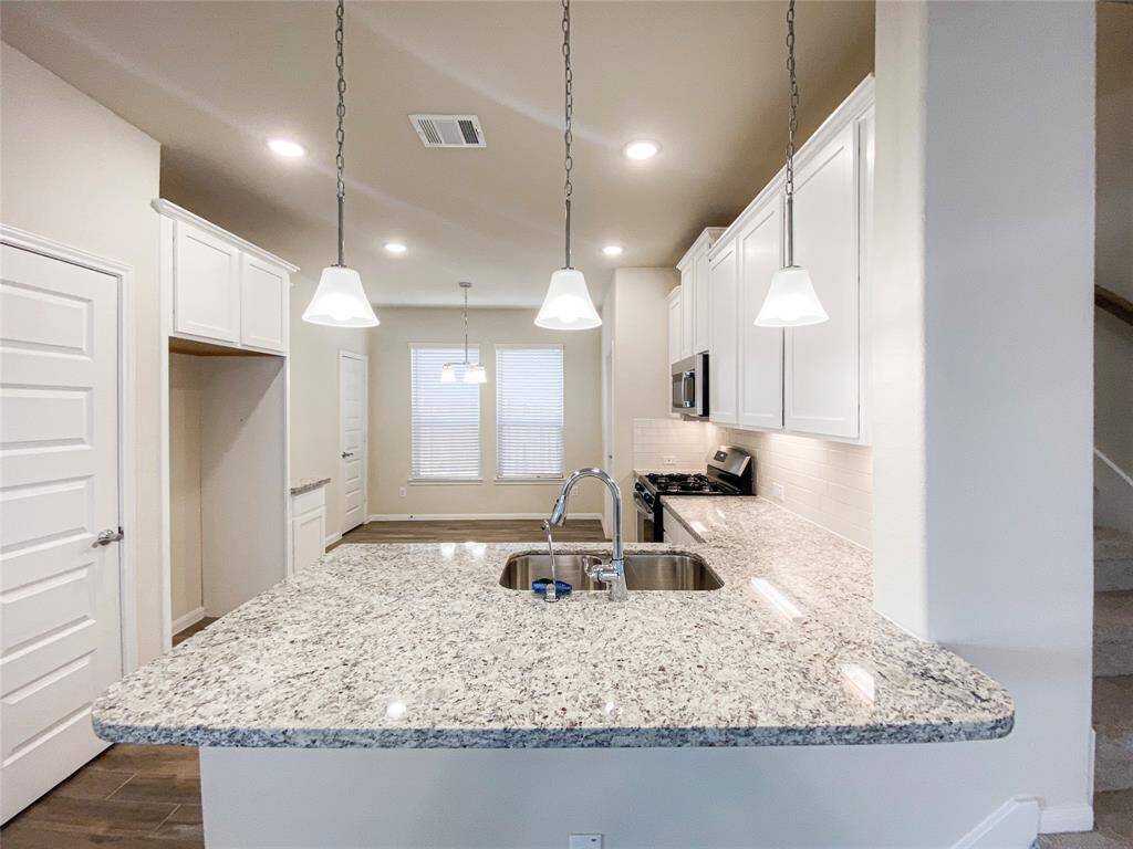 Granite countertops and white 42-inch cabinet and subway tile backsplash in kitchen