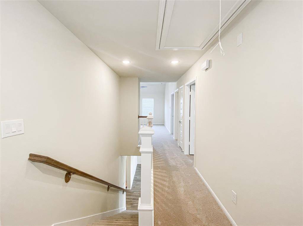 Upstairs hallway with handrails letting through natural light