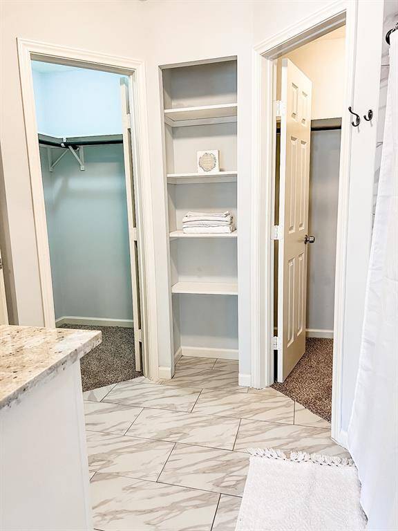 View of his and her closets inside the main bathroom area.