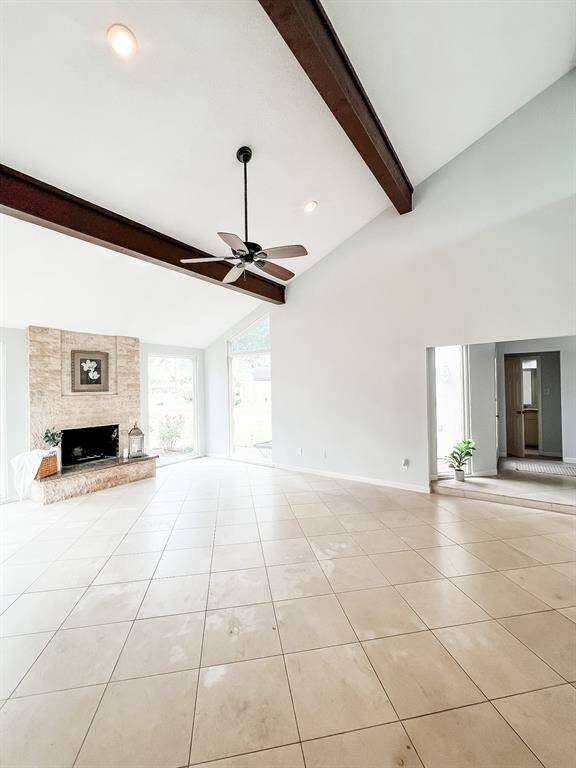 View of the living room area with beautiful wooden beams and high ceilings.