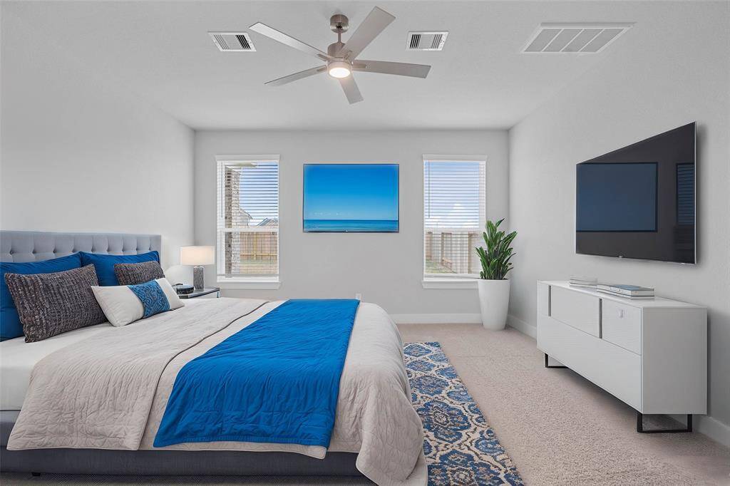 Come and unwind after a long day in this magnificent primary suite! This spacious room features plush carpet, warm paint, high ceilings with ceiling fan and large windows with privacy blinds.