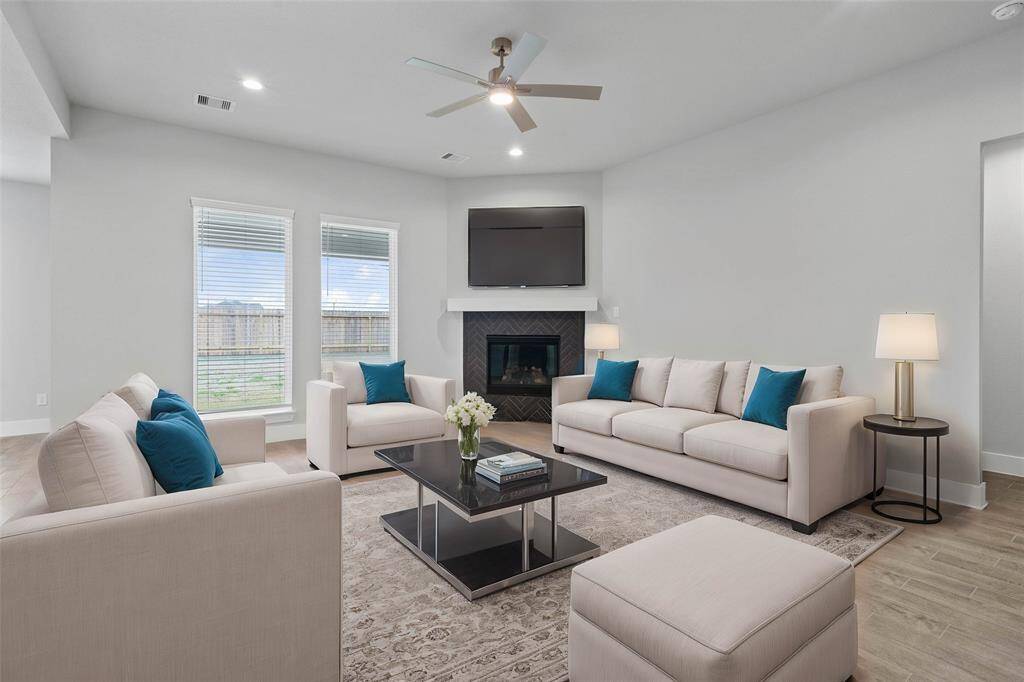 Gather the family and guests together in your lovely family room! Featuring fireplace with wood mantel, high ceilings with ceiling fan, recessed lighting, custom paint, beautiful wood-look tile floors, and large windows that provide plenty of natural lighting throughout the day.