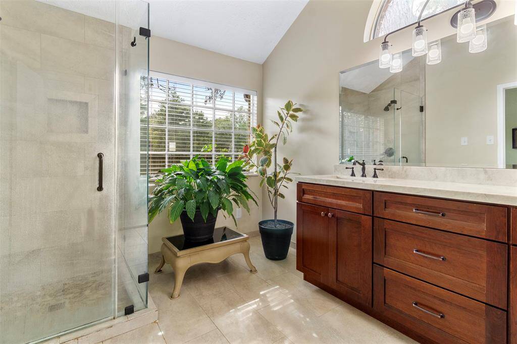 The primary bathroom also has a walk-in shower with glass door and surround.