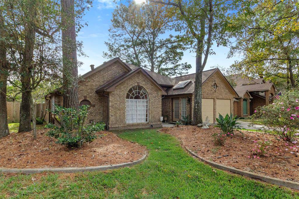 This home has tall trees for plenty of shade, landscaping, and brick exterior.