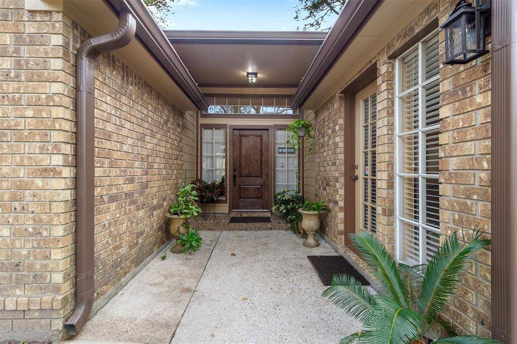 Approaching the front door you will see the dark stained front door and large windows.