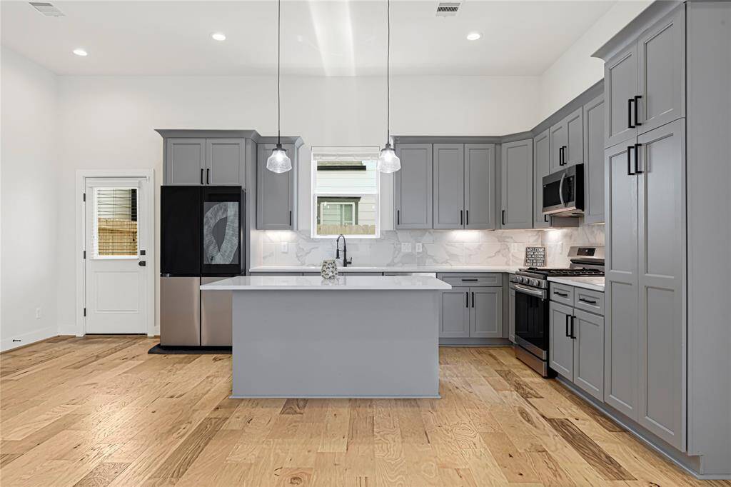 Gourmet kitchen equipped with stainless steel appliances, custom cabinetry, and a spacious center island.