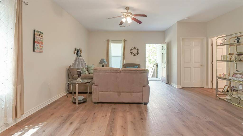 Bright and welcoming, this spacious living room features wood-look flooring, neutral tones, and an open layout perfect for relaxing or entertaining. Natural light and cozy seating make it feel like home.